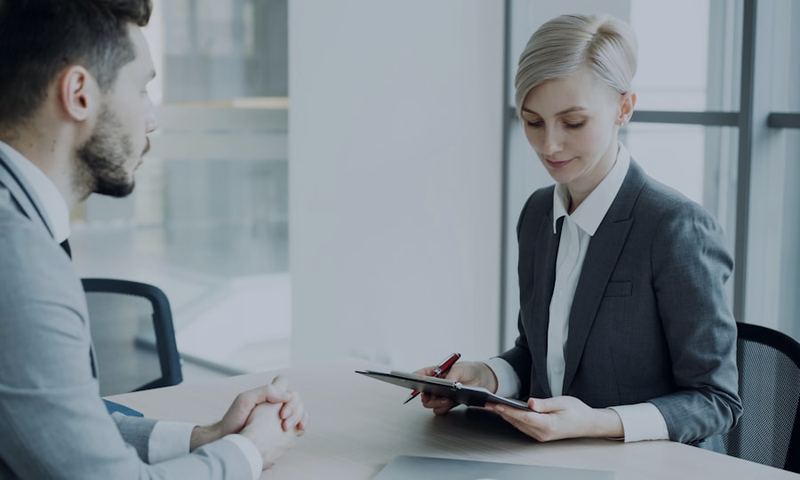 A manager reviewing a document with a candidate across a desk