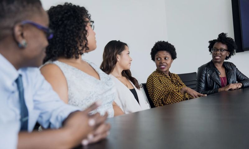 Five colleagues discussing together around a table
